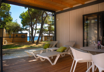Terrazza esterna con lettini e vista mare presso Deluxe Camping Villa Sea View, Camping Arena Stoja, Croazia.