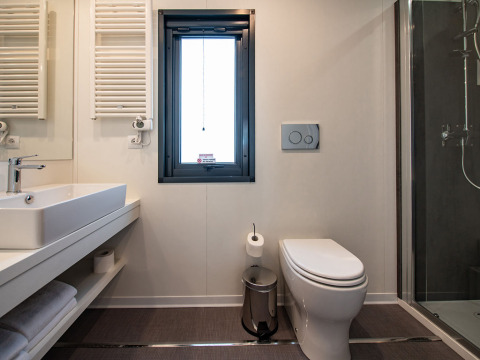 Bagno moderno presso Deluxe Camping Villa al Camping Arena Stoja in Croazia, con doccia e WC.