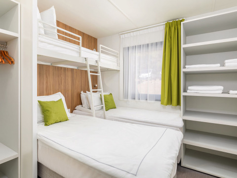 Camera luminosa moderna con letto a castello e due singoli nella Deluxe Camping Villa Sea View, Arena Stoja.
