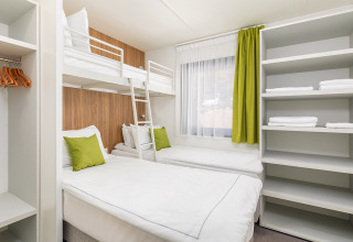 Luxe campingvilla met stapelbed, aparte bedden, open rekken en groene tinten, Arena Stoja, Kroatië.