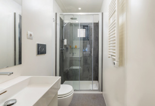 Modern bathroom with shower, towel radiator, and mirror in Deluxe Camping Villa First Row, Croatia.