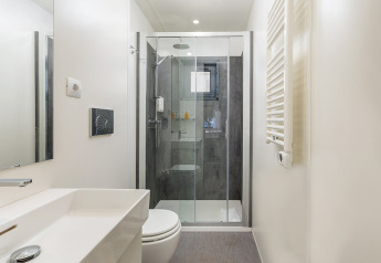 Moderne badkamer met douche, handdoekradiator en spiegel in de Deluxe Camping Villa First Row, Kroatië.