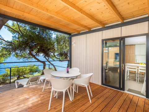 Houten terras met zeezicht en moderne meubelen bij Deluxe Camping Villa First Row, Camping Arena Stoja, Kroatië.