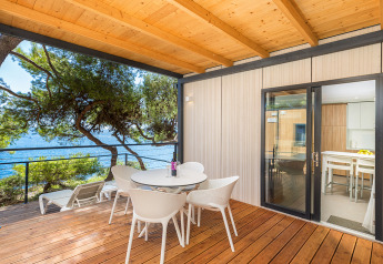 Wooden terrace with sea view and modern furniture at Deluxe Camping Villa First Row, Camping Arena Stoja, Croatia.