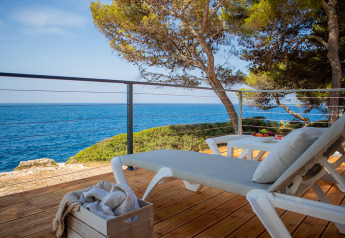 Villa deluxe con lettini e vista mare presso Camping Arena Stoja in Croazia, circondata da pini.