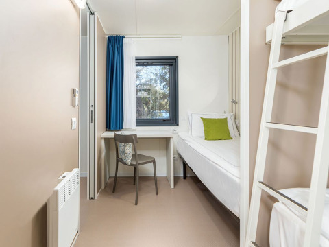 Camera luminosa e compatta presso Camping Villa First Row, Camping Arena Stoja, Croazia, con letto a castello e scrivania.