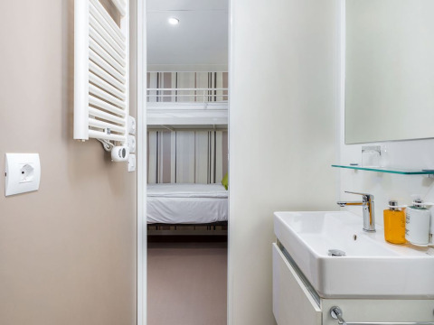 Modern chalet bathroom and view into room with bunk bed at Camping Villa First Row, Arena Stoja, Croatia.