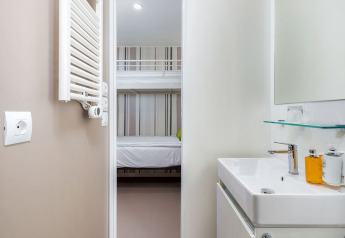 Baño moderno de chalet y vista al dormitorio con litera en Camping Villa First Row, Arena Stoja, Croacia.