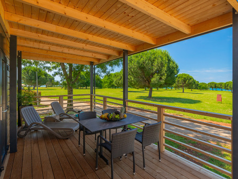 Wooden terrace with table, chairs, and loungers at Park Riviera Adria Blue Seaside, Camping Park Umag, Croatia.