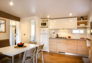 Modern kitchen and dining area at Lopar Garden Home, Valamar Camping San Marino, Croatia, with bright decor.