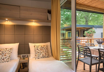 Vista interna del lodge Lopar Garden Home con due letti e accesso alla terrazza presso Valamar Camping San Marino.