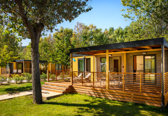 Lodge Lopar Garden Home con veranda in legno immersa nel verde, atmosfera tranquilla e rilassante.