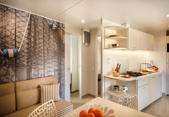 Cucina e zona pranzo moderna nel Marena Home lodge al Valamar Camping Baška, Croazia, con arredo luminoso.