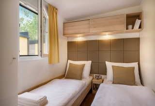 Camera doppia moderna con due letti singoli e finestra aperta al Vela Bay Home, Valamar Camping Baška, Croazia.