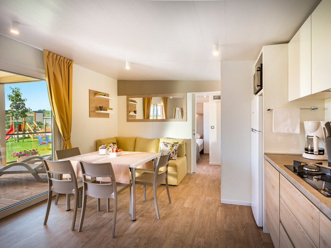 Innenansicht der Bella Vista Home Lodge im Valamar Camping Krk, Kroatien, mit moderner Küche und Essbereich.