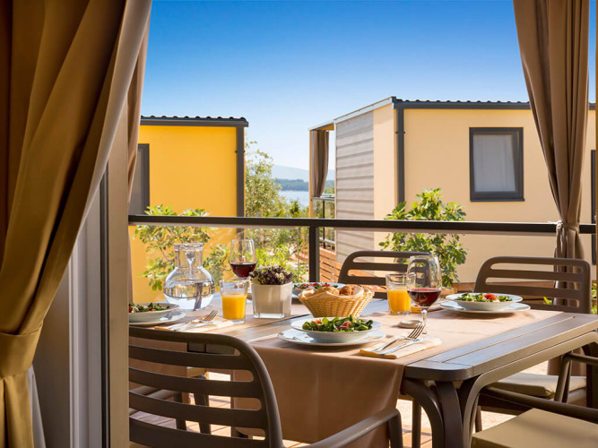 Desayuno en la terraza de Bella Vista Home en Valamar Camping Krk, Croacia, con cabañas y vista al mar.