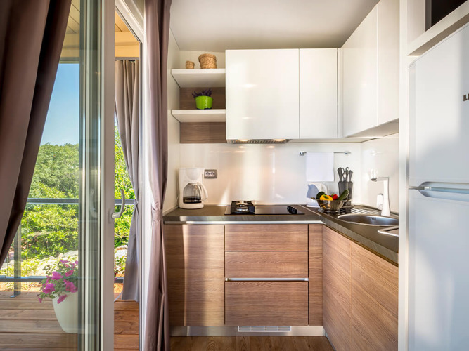 Cocina moderna en Bella Vista Home Garden terrace de Valamar Camping Krk, Croacia, con vista al balcón.