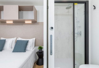 Modernes Camping Home bei Camping Arena Stupice in Kroatien mit Schlafzimmer, Doppelbett und Dusche.