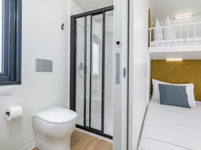 Camera compatta con WC, doccia e letti a castello presso Camping Home a Camping Arena Stupice, Croazia.