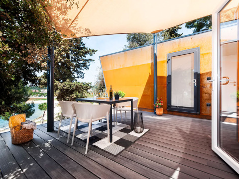 Outdoor terrace with dining table and chairs at Family Holiday Home Pool, Camping Porton Nature Hideouts, Croatia.
