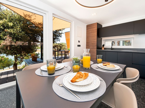 Modernes Küchen- und Essbereich mit Blick auf die Terrasse und Natur in der Family Holiday Home Pool – 2 Module, Camping Porton Nature Hideouts, Kroatien.