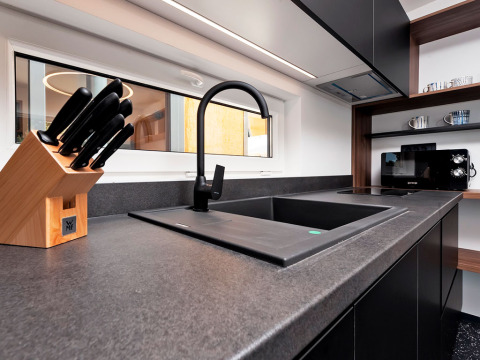 Moderne keuken met zwarte kraan, messenblok en microgolf in Family Holiday Home Pool, Porton Nature, Kroatië.