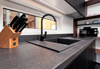 Modern kitchen sink with black faucet, knife block, and microwave in Family Holiday Home Pool, Porton Nature, Croatia.