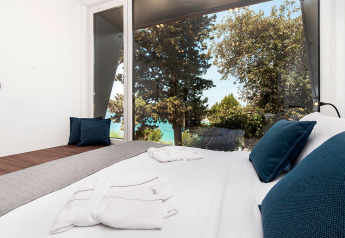 Dormitorio moderno en Family Holiday Home Pool, con grandes ventanales y vistas al mar y árboles en Croacia.