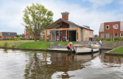 Buitenzijde Eneva met bootje op het water - Tusken de Marren - Akkrum, Friesland, Nederland