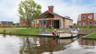 Buitenzijde Eneva met bootje op het water - Tusken de Marren - Akkrum, Friesland, Nederland