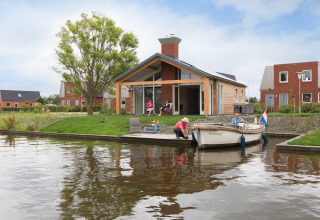 Buitenzijde Eneva met bootje op het water - Tusken de Marren - Akkrum, Friesland, Nederland