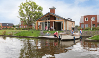 Buitenzijde Eneva met bootje op het water - Tusken de Marren - Akkrum, Friesland, Nederland