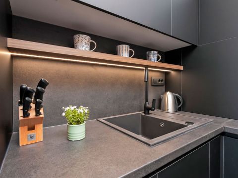 Moderne Küchenzeile mit grauer Arbeitsplatte, Spüle, Wasserkocher und Tassenregal in Kroatien-Lodge.