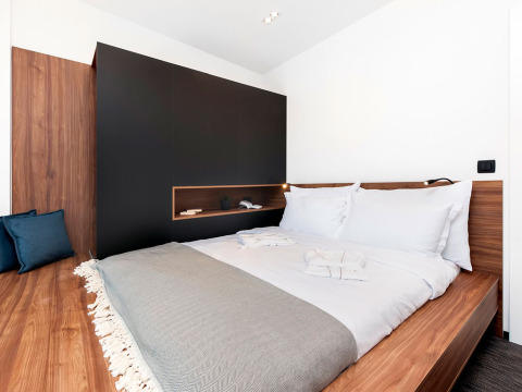 Modernes Schlafzimmer mit Doppelbett und Holzmöbeln im Couple Holiday Home Pool bei Camping Porton Nature Hideouts.