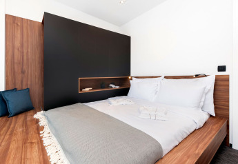 Dormitorio moderno con cama doble y muebles de madera en Couple Holiday Home Pool, Camping Porton Nature Hideouts, Croacia.