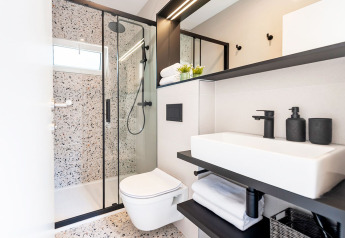 Modern bathroom with shower, wall-mounted toilet and sink at Couple Holiday Home Pool in Croatia.
