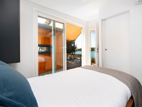 Slaapkamer in Family Holiday Home Pool met terras en uitzicht op zee bij Camping Porton Nature, Kroatië.