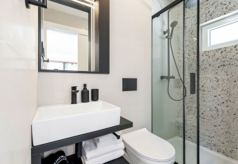 Bagno moderno con doccia in vetro, specchio illuminato e lavandino al Family Holiday Home Pool, Camping Porton, Croazia.