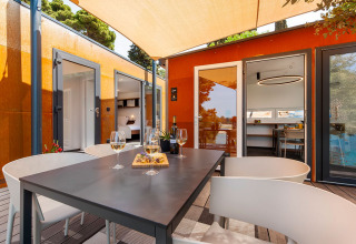 Buitenterras bij Family Holiday Home Pool op Camping Porton Nature Hideouts in Kroatië met wijn en hapjes.