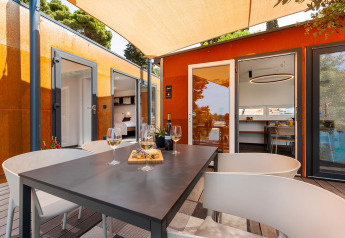 Terraza exterior en Family Holiday Home Pool de Camping Porton Nature Hideouts en Croacia con vino y aperitivos.