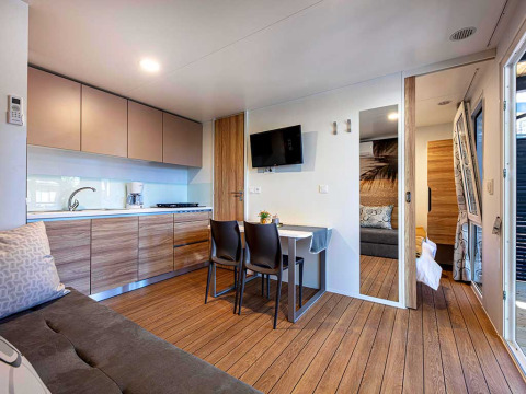 Moderne lodge bij Camping Porton Nature Hideouts in Kroatië met keuken, eettafel en zithoek.