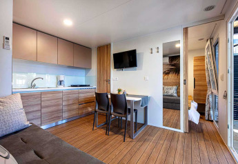 Moderne lodge bij Camping Porton Nature Hideouts in Kroatië met keuken, eettafel en zithoek.