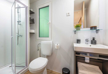 Moderne badeværelse med brusekabine, toilet, håndvask og spejl på Porton lodge, Camping Porton Nature Hideouts, Kroatien.