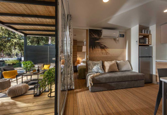 Interni eleganti e terrazza in legno del Porton Pool lodge presso Camping Porton Nature Hideouts in Croazia.