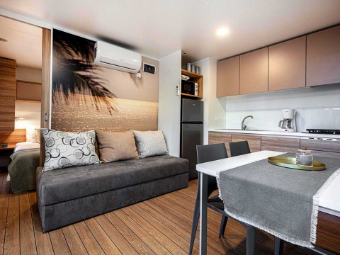 Moderne Lodge im Porton Pool, Camping Porton Nature Hideouts, Kroatien, mit Küche und Sofa.