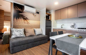 Modern lodge at Porton Pool in Camping Porton Nature Hideouts, Croatia with kitchen and living area.