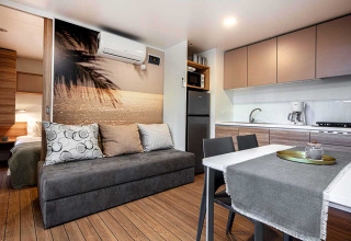 Moderne Lodge im Porton Pool, Camping Porton Nature Hideouts, Kroatien, mit Küche und Sofa.