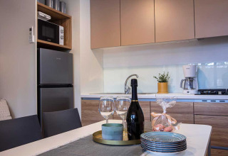 Moderne Küchenzeile im Porton Pool, Camping Porton Nature Hideouts, Kroatien, mit Gläsern und Tellern.