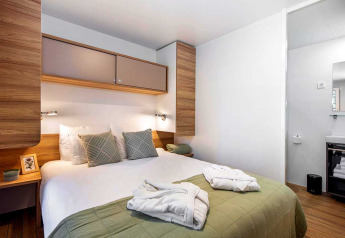 Moderne soveværelse på Porton Pool, Camping Porton Nature Hideouts, Kroatien, med dobbeltseng og bad.