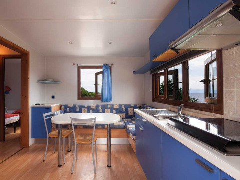 Cuisine et salle à manger modernes aux armoires bleues avec vue sur la mer à Baia Lux, Baia Holiday Poljana, Croatie.